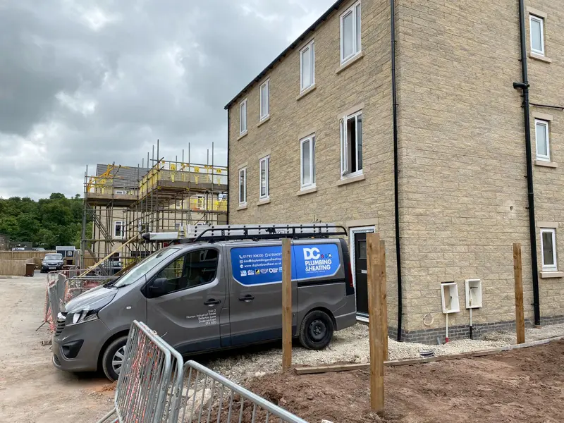 DC Plumbing & Heating van outside new build houses under construction