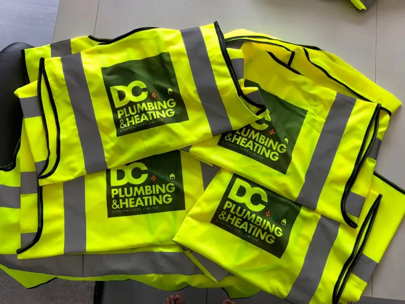 Hi-vis vests printed with the DC Plumbing & Heating logo