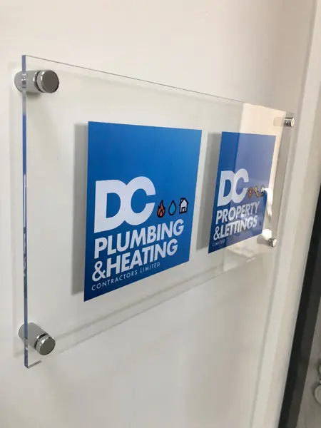 DC Plumbing & Heating and DC Property & Lettings signs on an office wall