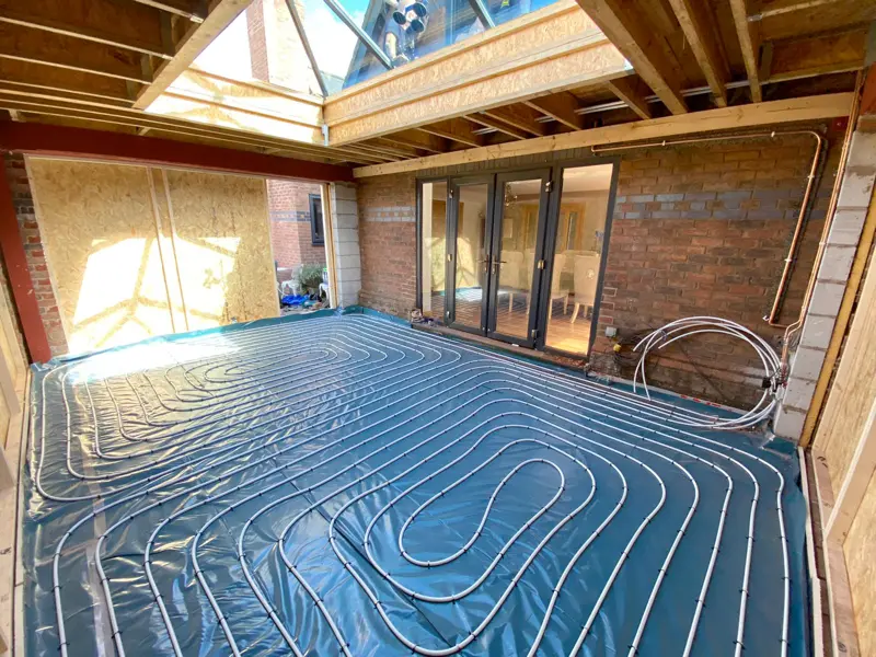 Underfloor heating pipes laid in an extension under a glass lantern roof